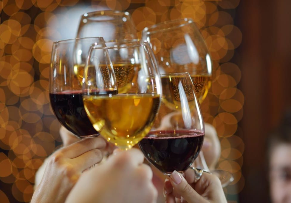 Celebration. Hands holding the glasses of champagne and wine making a toast.