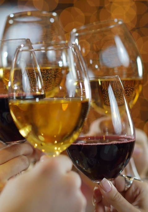 Celebration. Hands holding the glasses of champagne and wine making a toast.